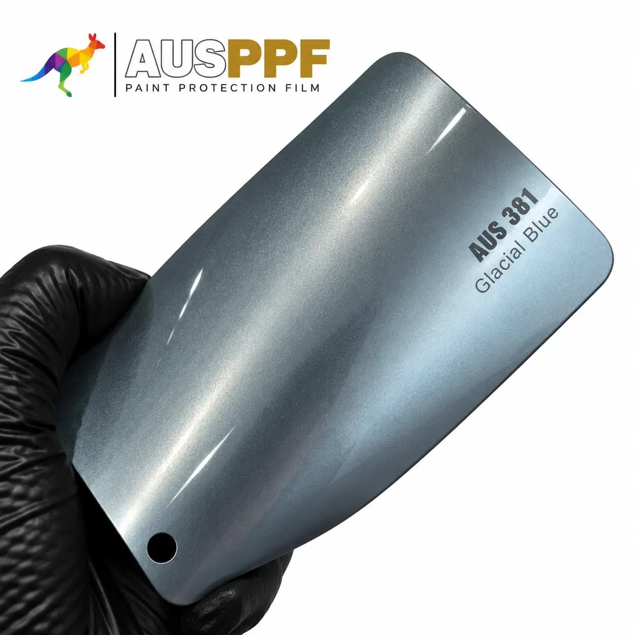A gloved hand holding a swatch of AusPPF AUS-381 Glacial Blue PPF, showing its gloss finish.