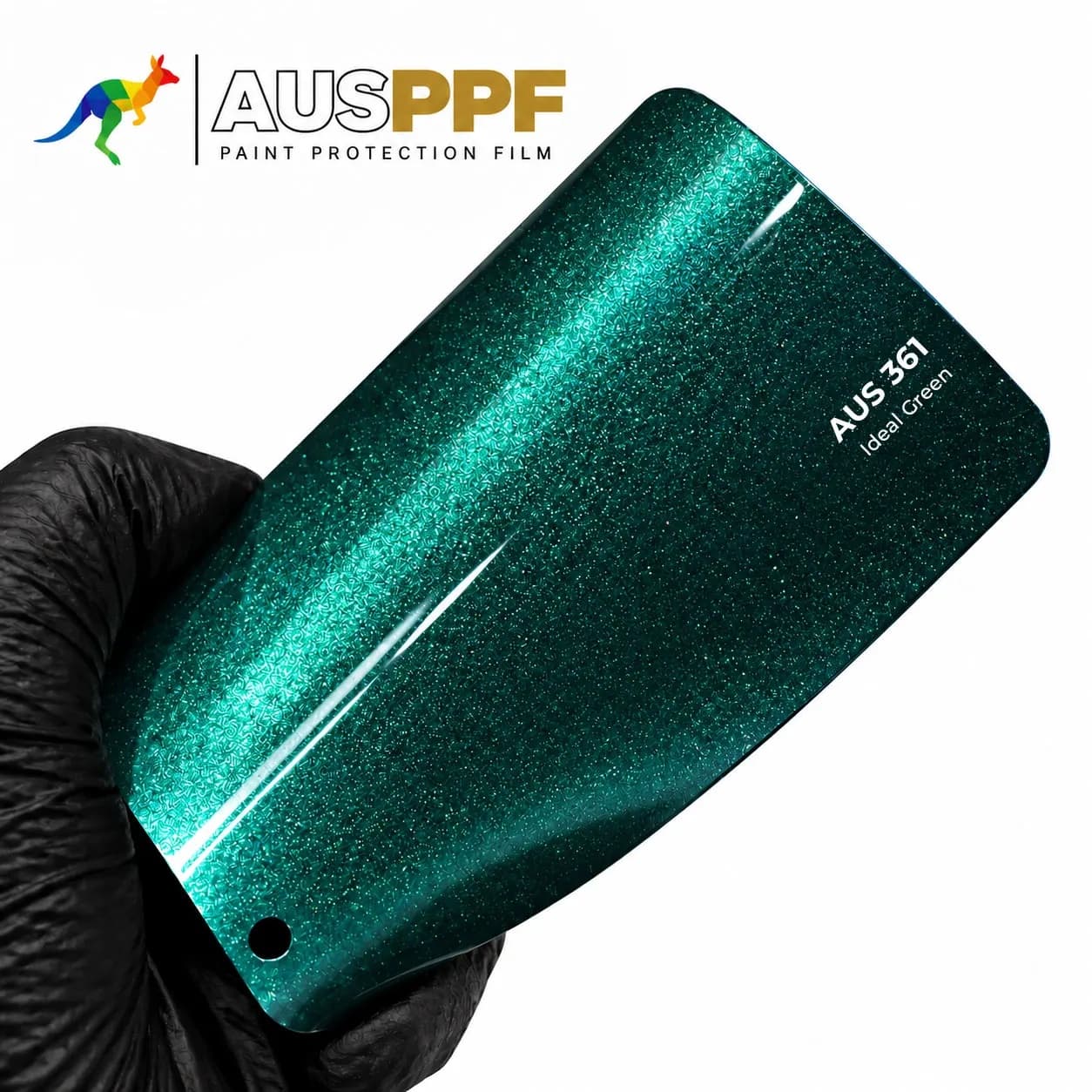A gloved hand holding a swatch of AusPPF AUS-361 Ideal Green PPF, showing its gloss finish.
