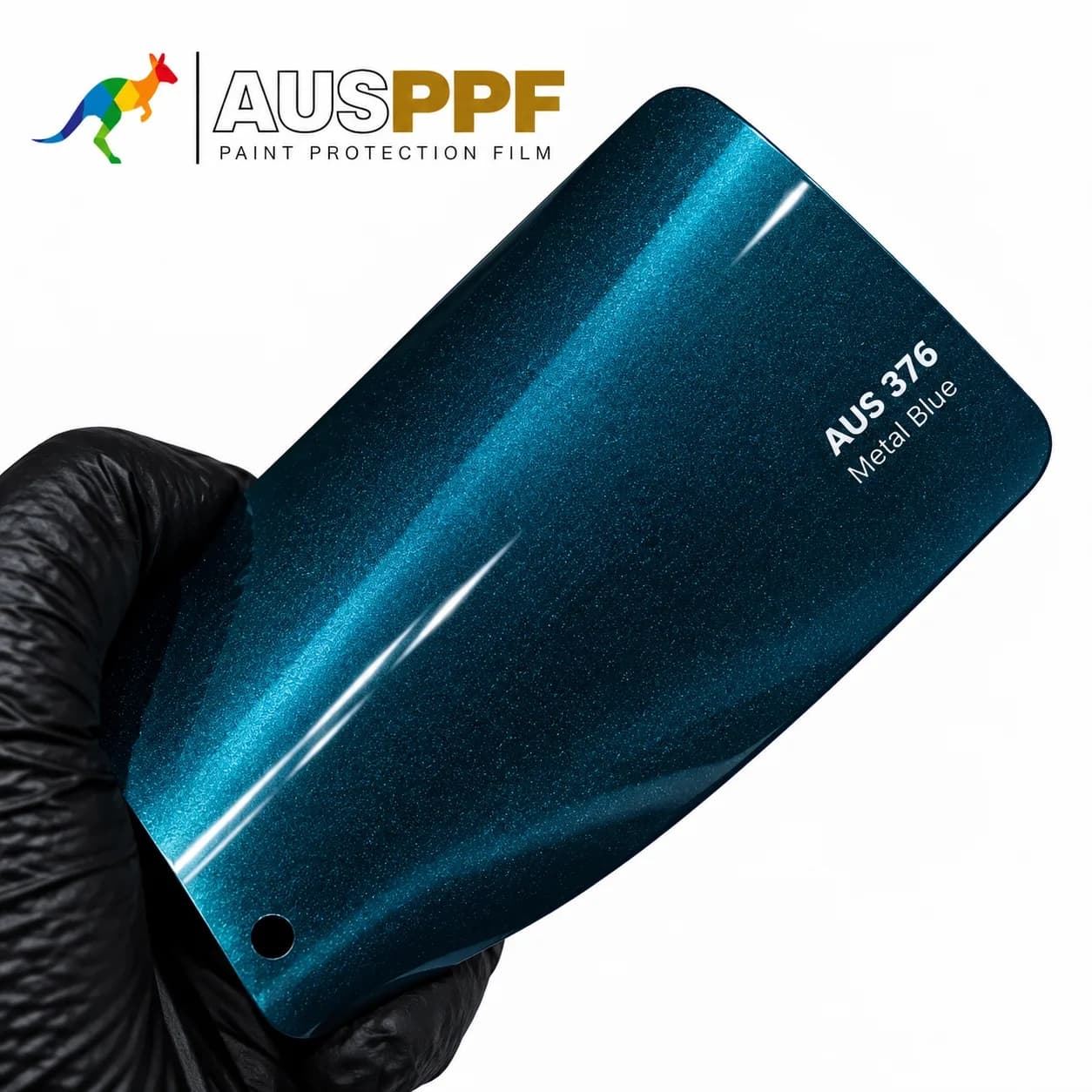 A gloved hand holding a swatch of AusPPF AUS-376 Metal Blue PPF, showing its gloss finish.