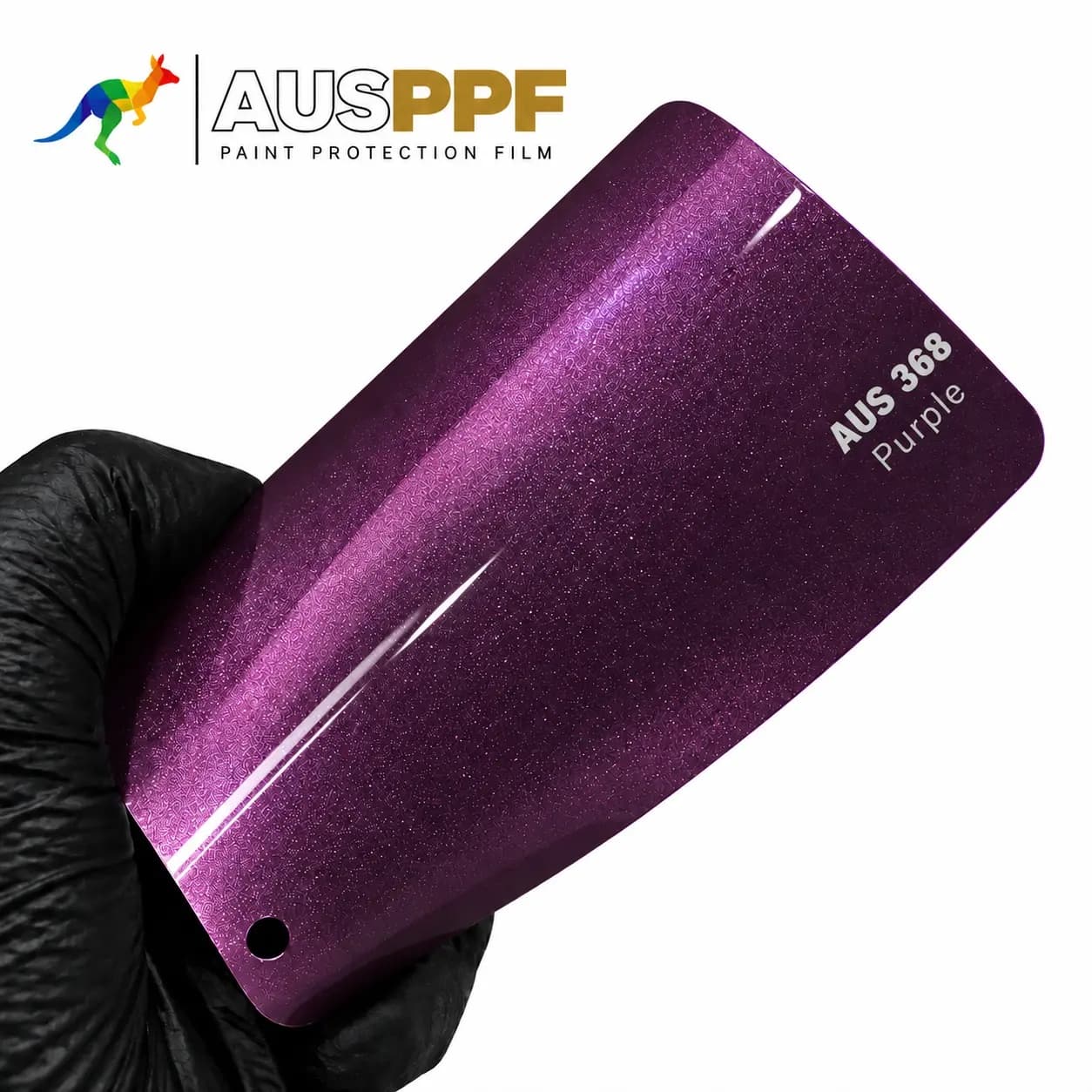 A gloved hand holding a swatch of AusPPF AUS-368 Purple PPF, showing its gloss finish.